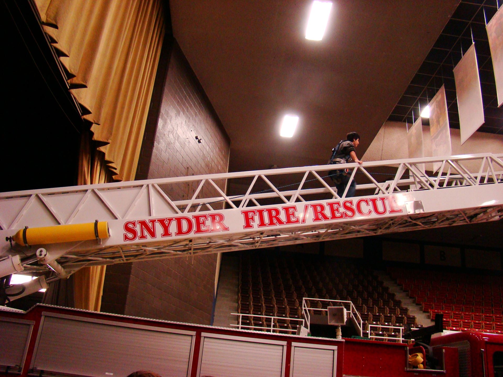 Student climbs ladder extended from fire truck.